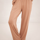 The pants of the Long-Sleeved Women's Pajama Set in Latte with Latte Trim shown on a model