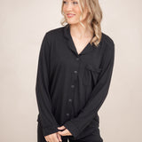 Close up of a female modeling the Long-Sleeved Women's Pajama Set in Midnight with Midnight Trim standing in front of a light neutral background