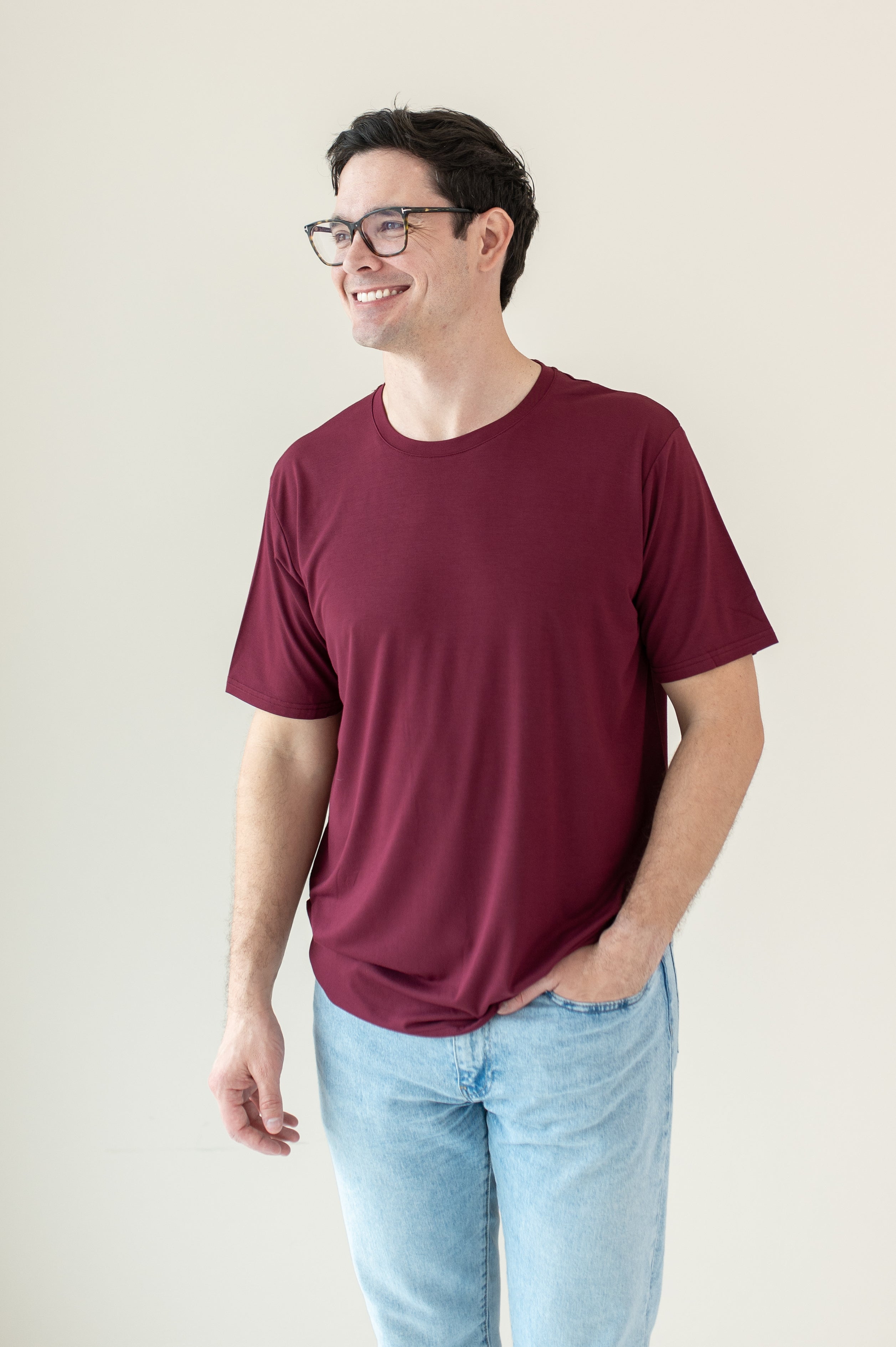 Male model wearing Men's Crew Neck Tee in Burgundy paired with jeans