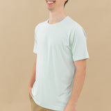 Man modeling Men's Crew Neck Tee in Dew with hand in shorts pocket