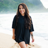 Smiling female in the sand on the beach wearing the Women’s Biker Short Set in Midnight