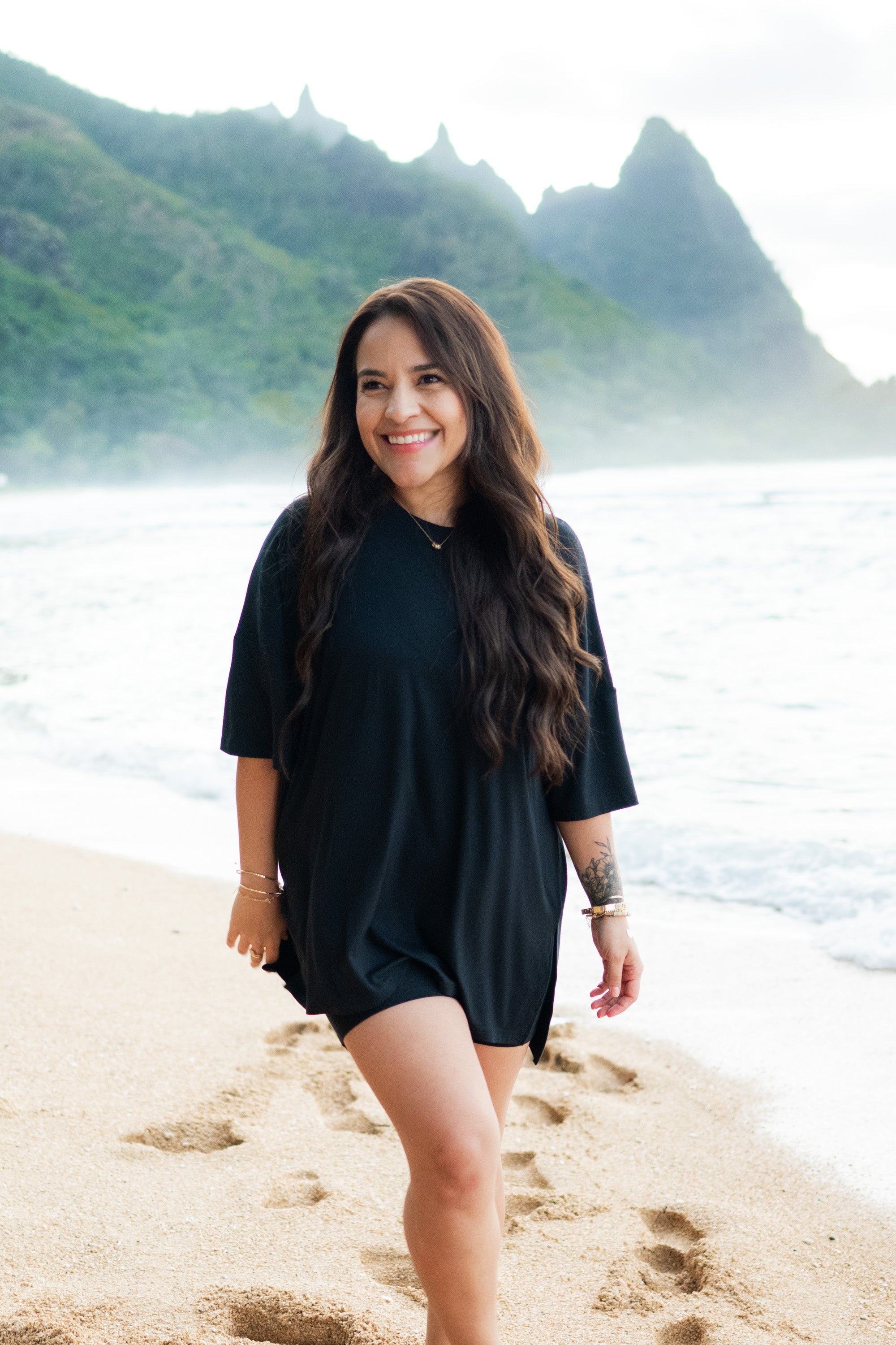 Smiling female in the sand on the beach wearing the Women’s Biker Short Set in Midnight