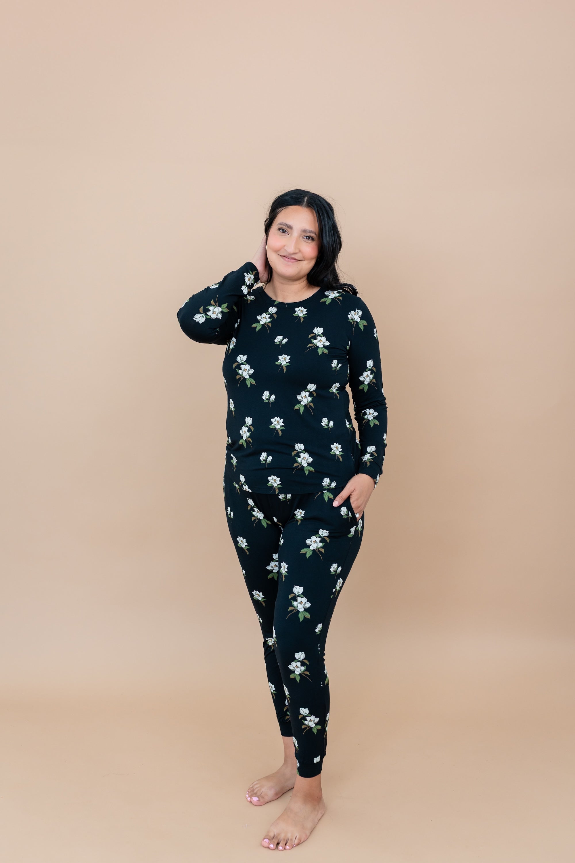Woman wearing a Big Midnight Magnolia black floral pajama set with hand in pocket