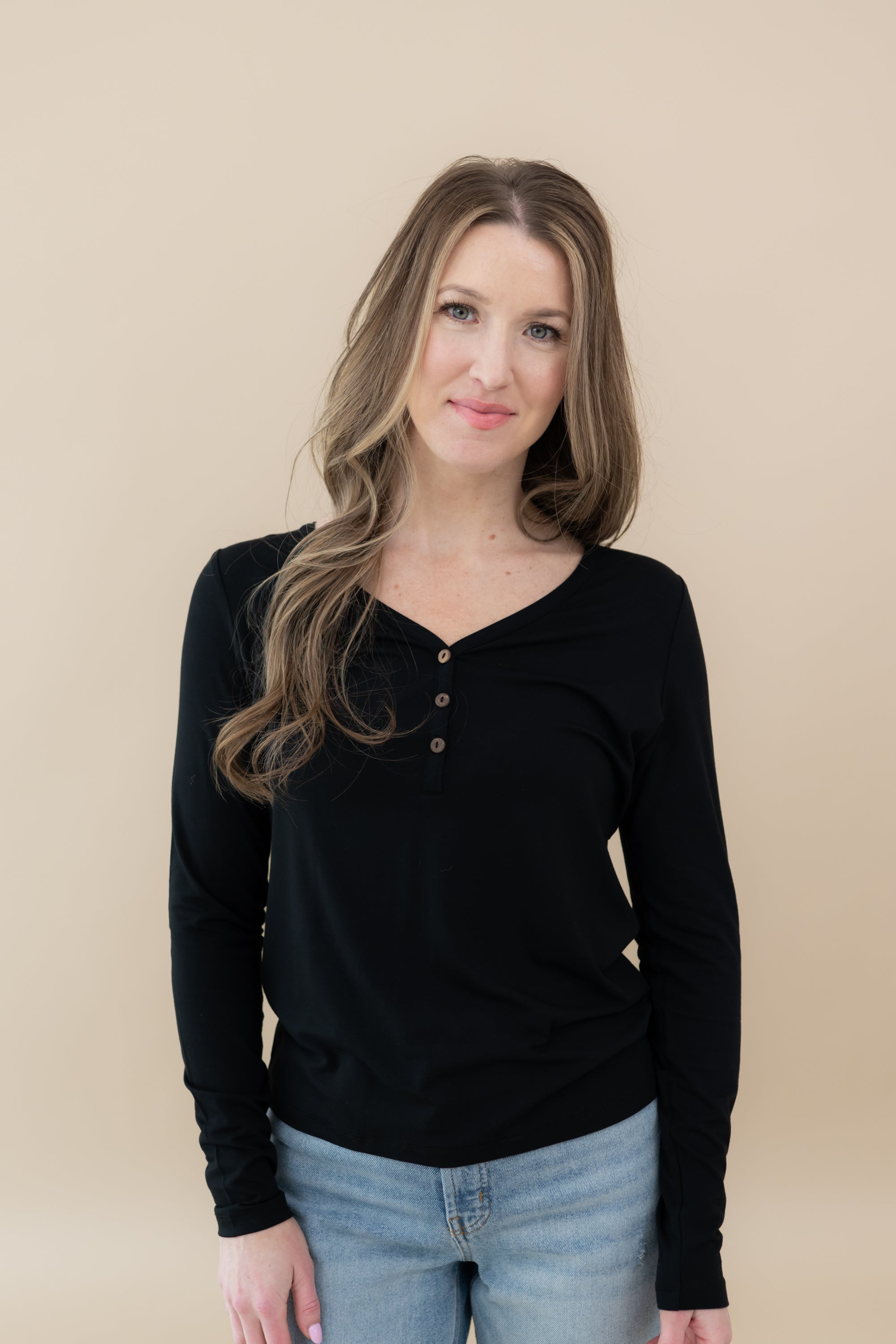 Woman wearing Women's Long Sleeve Henley Tee in Midnight and jeans