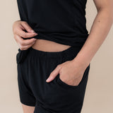 Model showcasing the elastic waistband and pocket in the shorts for the Women’s Tank Set in Midnight