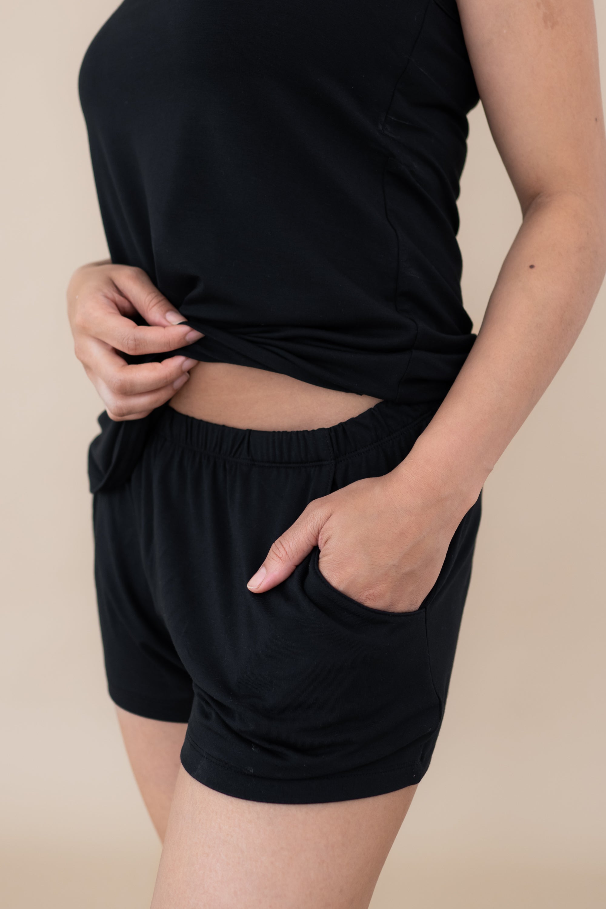 Model showcasing the elastic waistband and pocket in the shorts for the Women’s Tank Set in Midnight