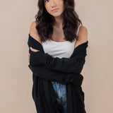Woman wearing the Kyte Women's French Terry Wrap Top in Midnight off of her shoulders paired with a cami in cloud