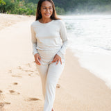 Model walking on the beach wearing the Women's Jogger Pajama Set in Oat