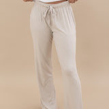 Model wearing the Women's Lounge Pants in Oat paired with a white shirt