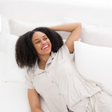 Female model laying on a bed wearing Women's Short Sleeve Pajama Set in Oat