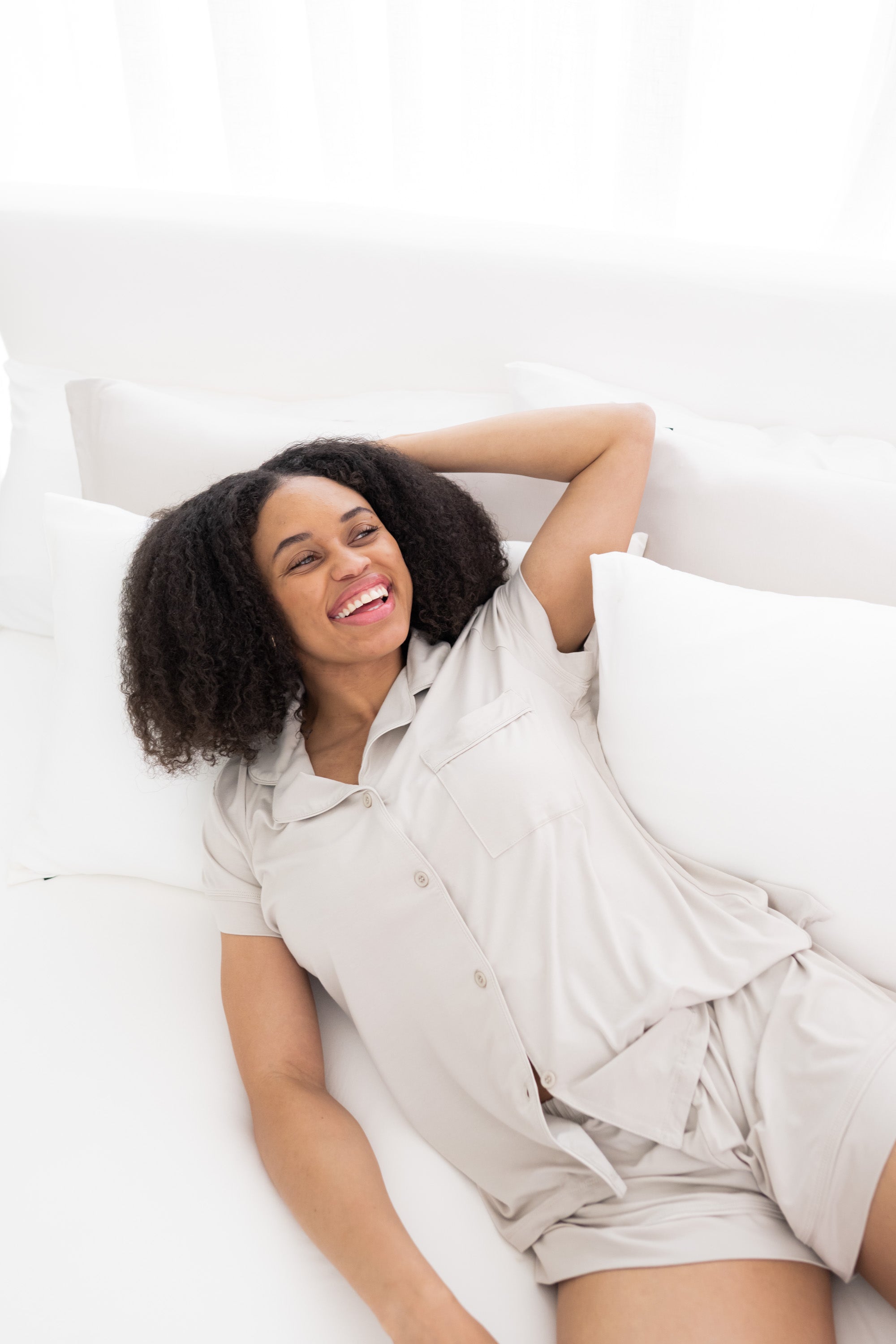Female model laying on a bed wearing Women's Short Sleeve Pajama Set in Oat