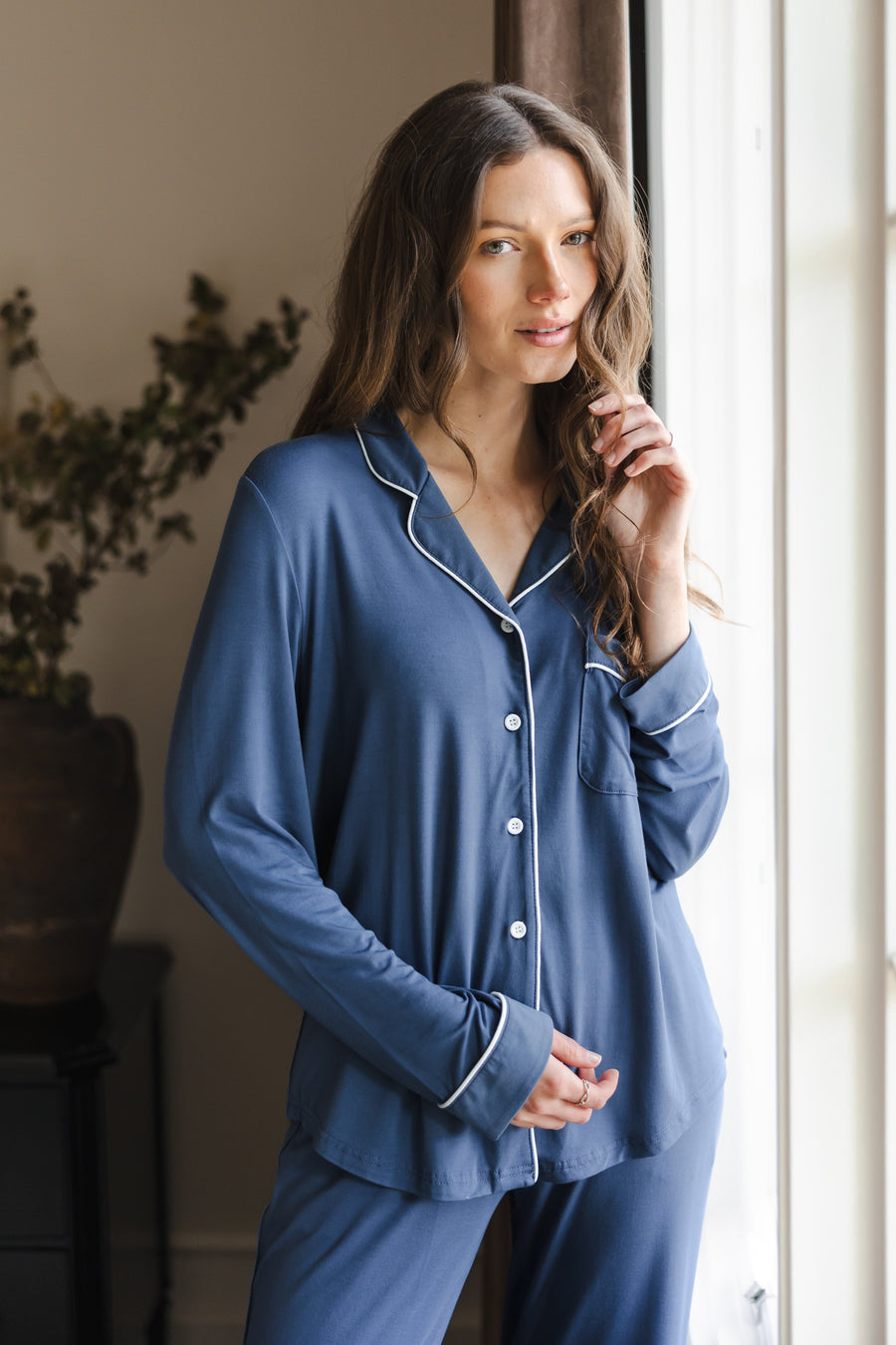 Modal posing in Long-Sleeved Women's Pajama Set in Oxford standing against a large window