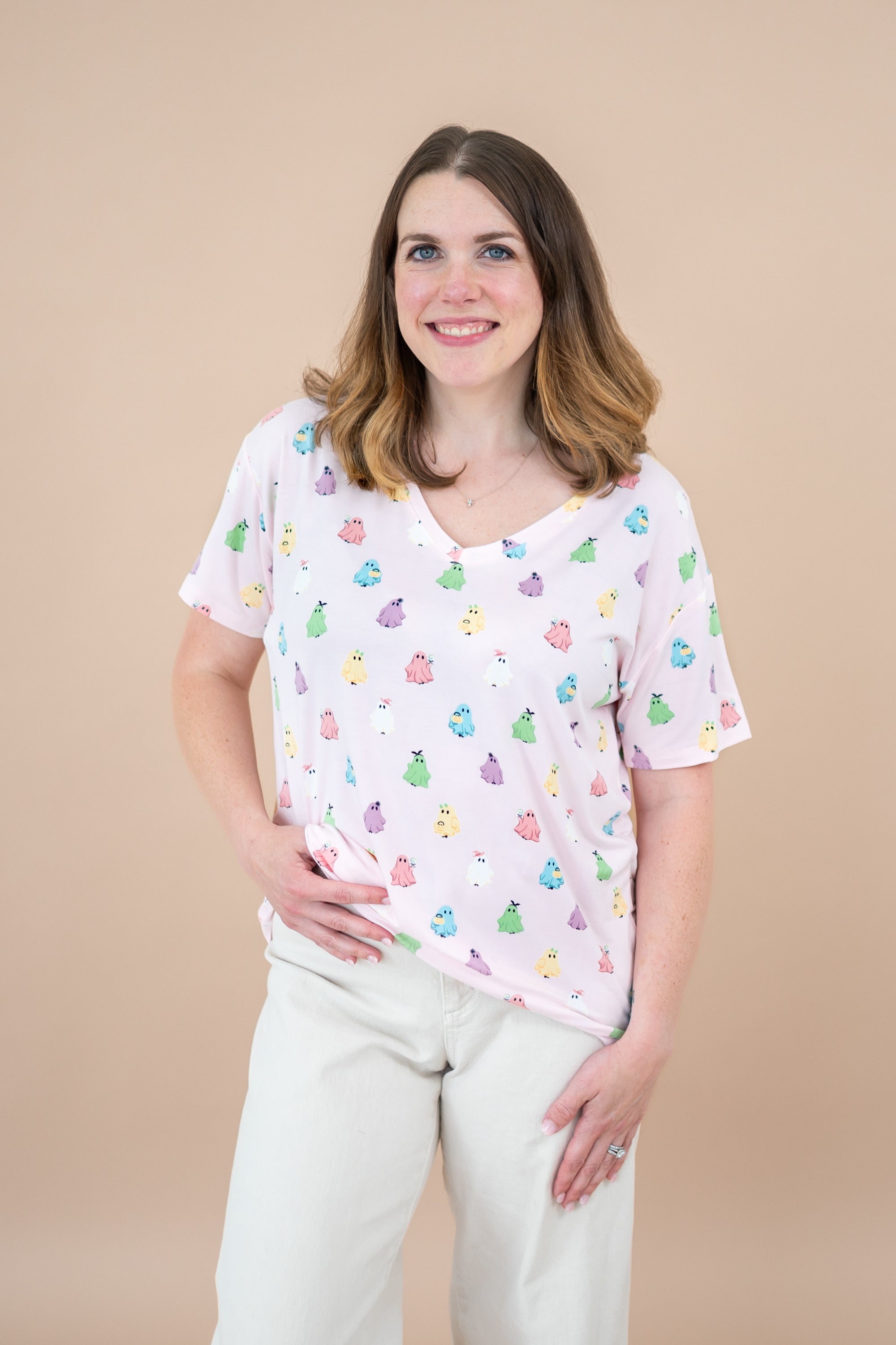 Smiling model with hand on hip wearing the Kyte Women's V-Neck in Pastel Ghost