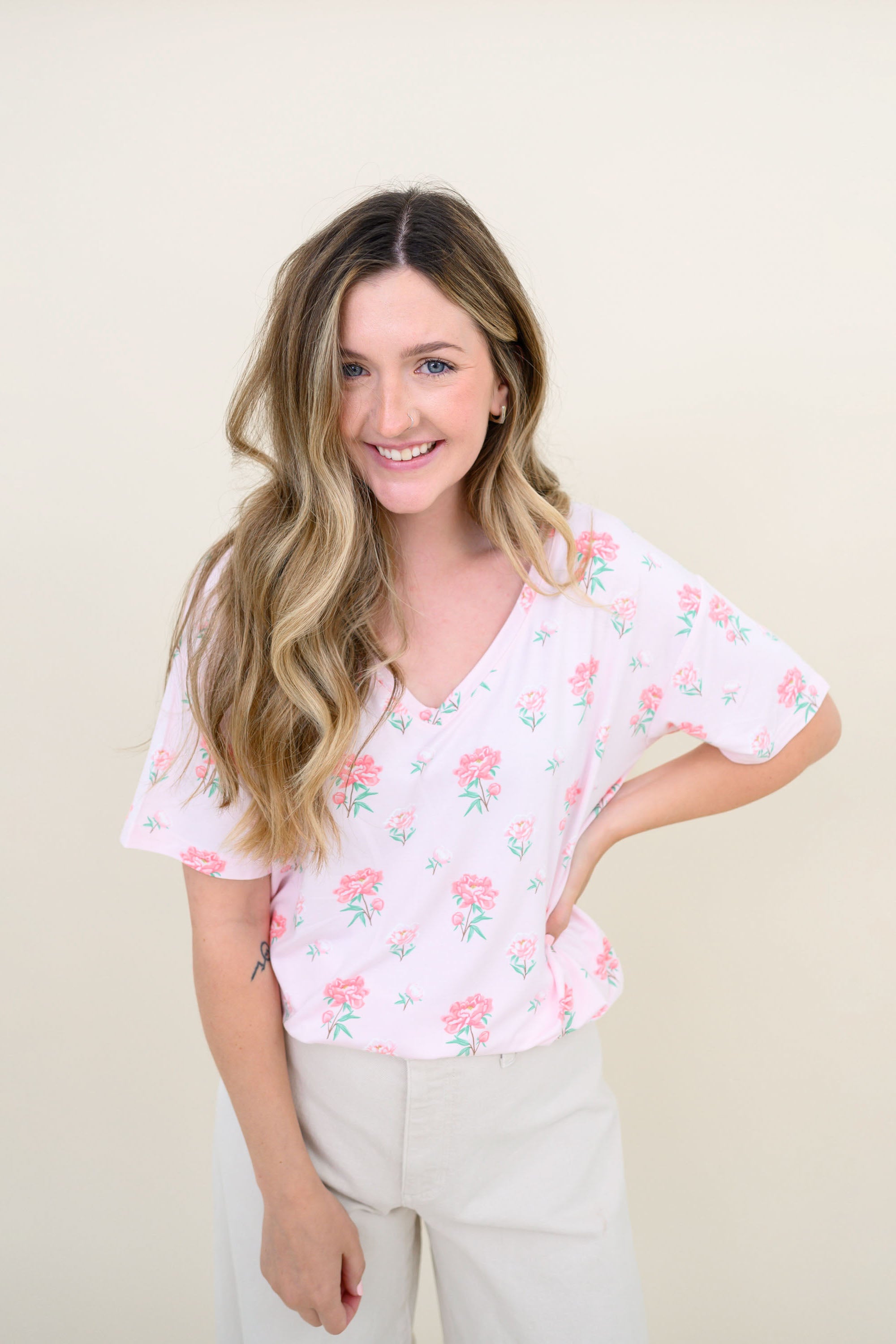 Woman modeling Women's Relaxed Fit V-Neck in Sakura Peony and light colored pants