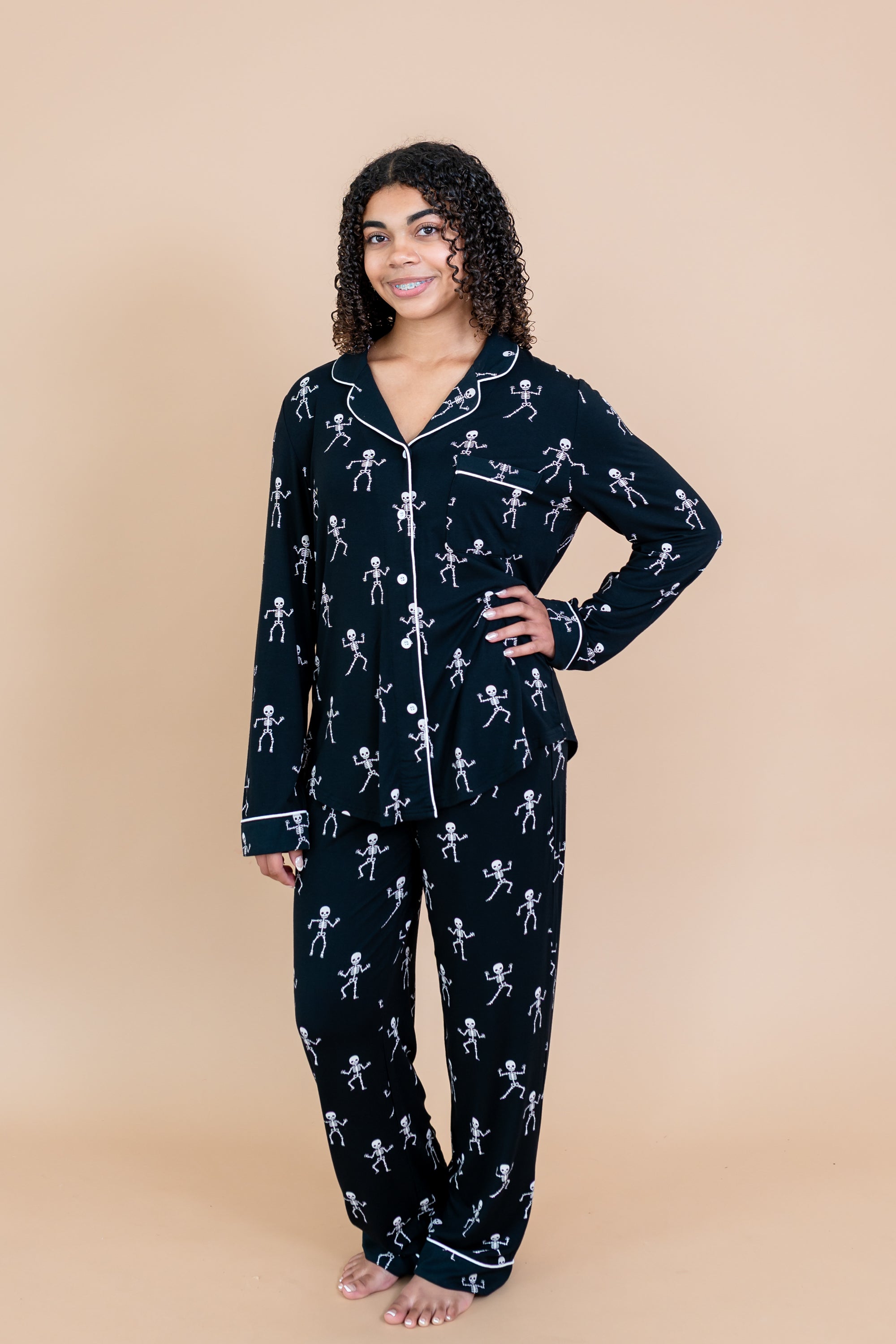 Woman with arm on hip modeling Kyte Long Sleeve Women's Pajama Set in Skeleton