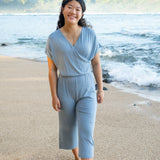 Smiling model walking on the beach wearing the Women's Ribbed Jumpsuit in Slate
