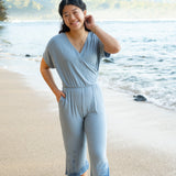 Model in the sand on the beach wearing the Women's Ribbed Jumpsuit in Slate with one hand in pocket