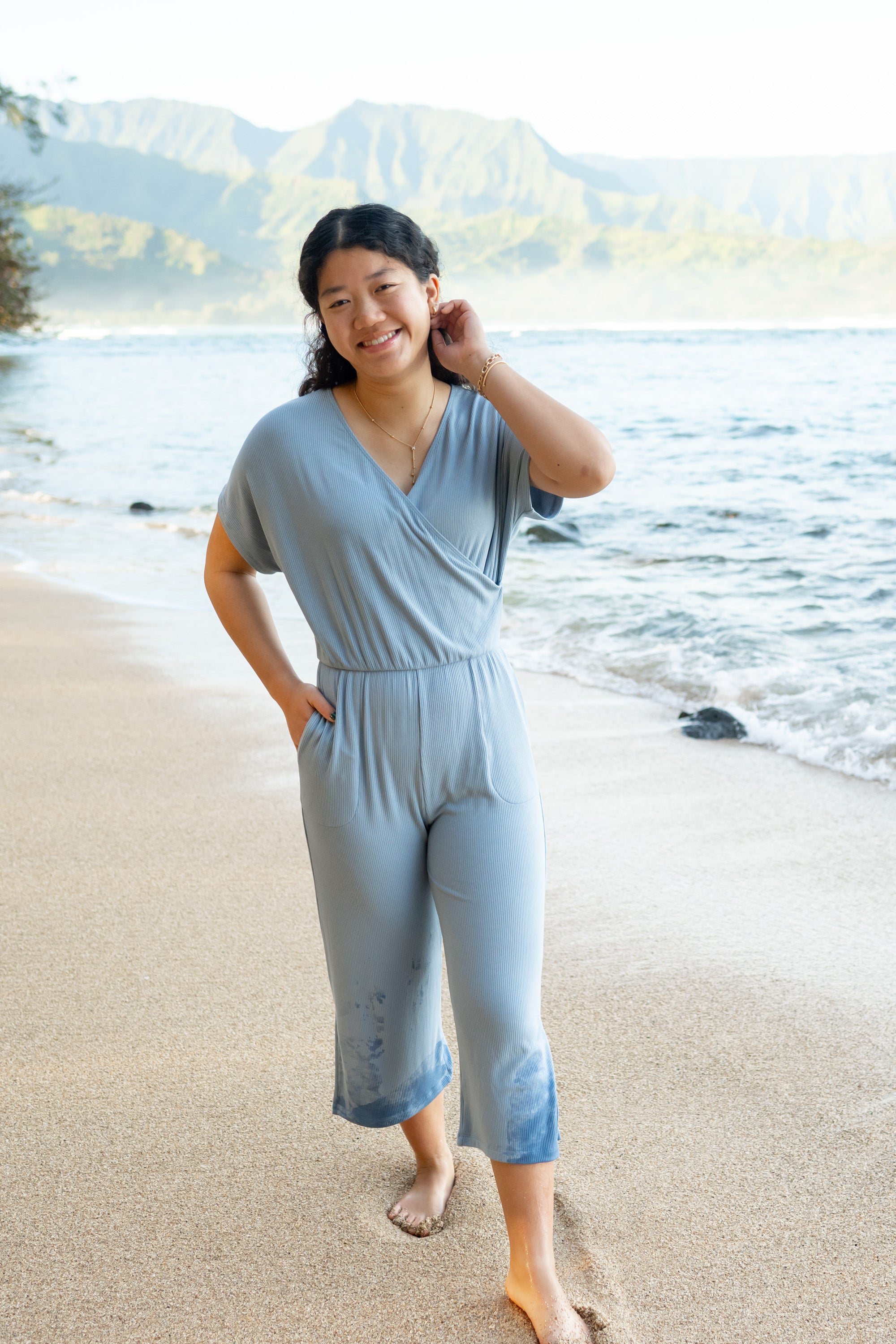 Model in the sand on the beach wearing the Women's Ribbed Jumpsuit in Slate with one hand in pocket