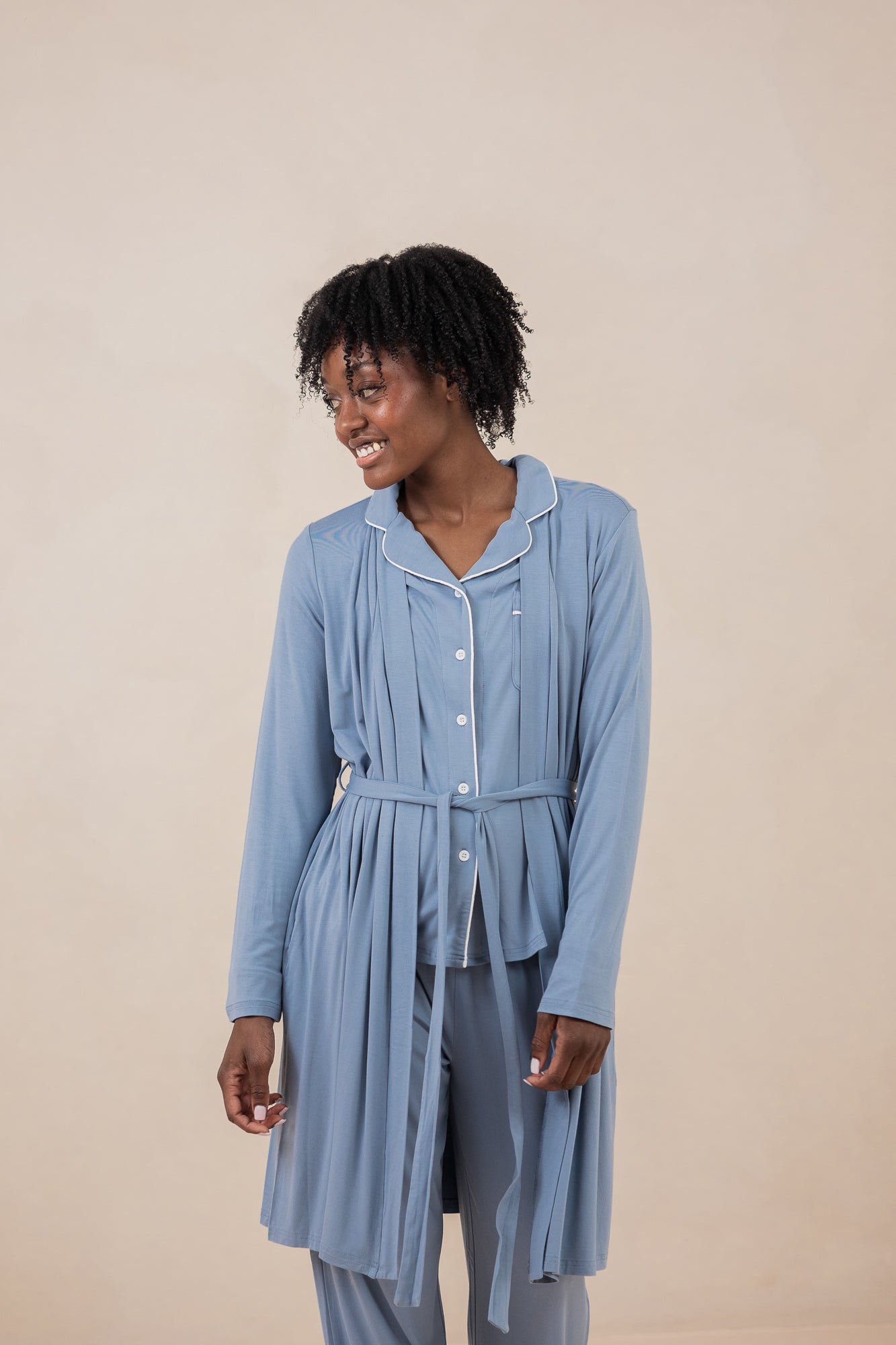 Model smiling to the side while wearing the Women's Robe in Slate and matching Long Sleeve Pajama Set underneath