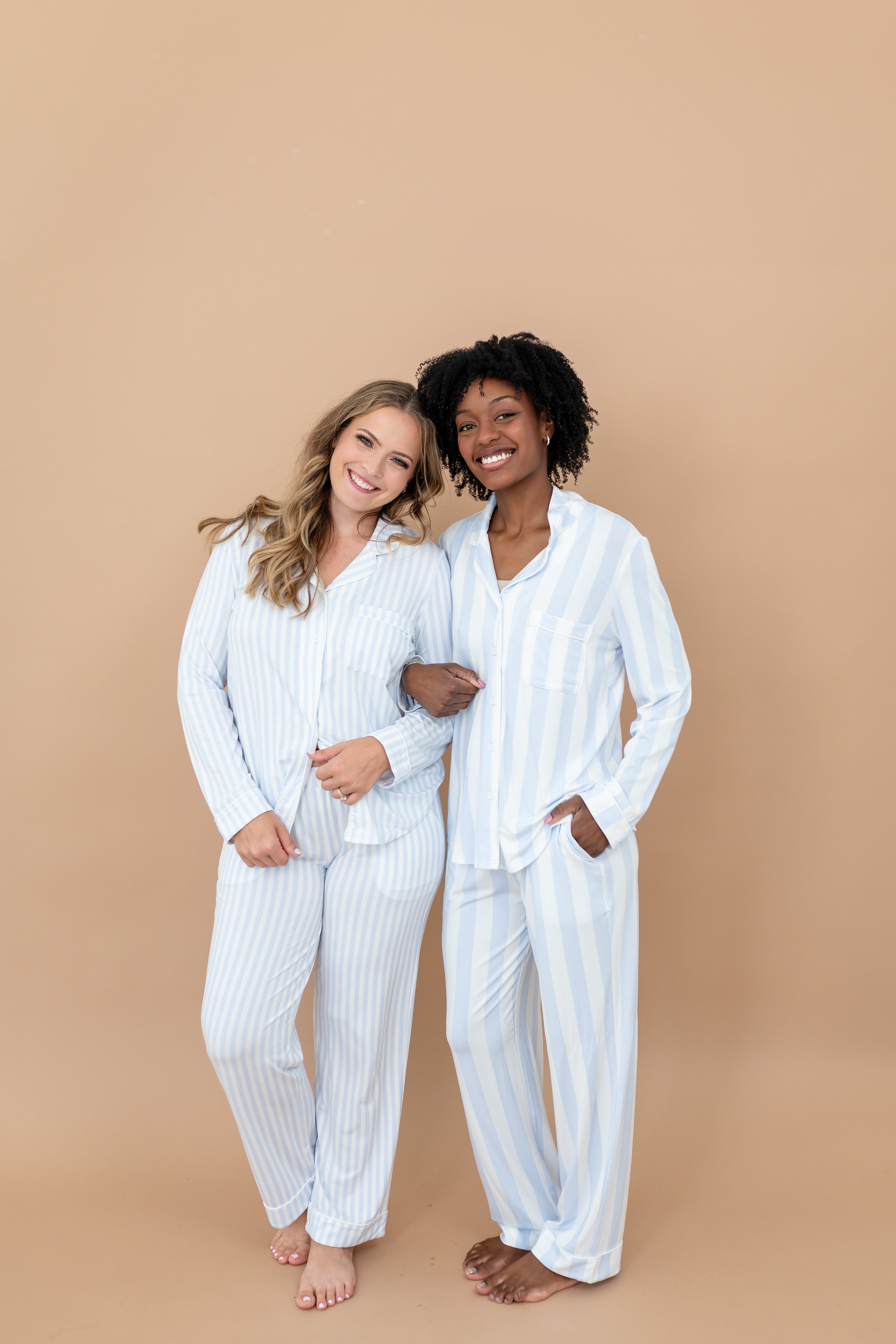 Two female models standing side by side with their arms linked wearing the Long-Sleeved Women's Pajama Set in Big Mist Stripe and Small Mist Stripe