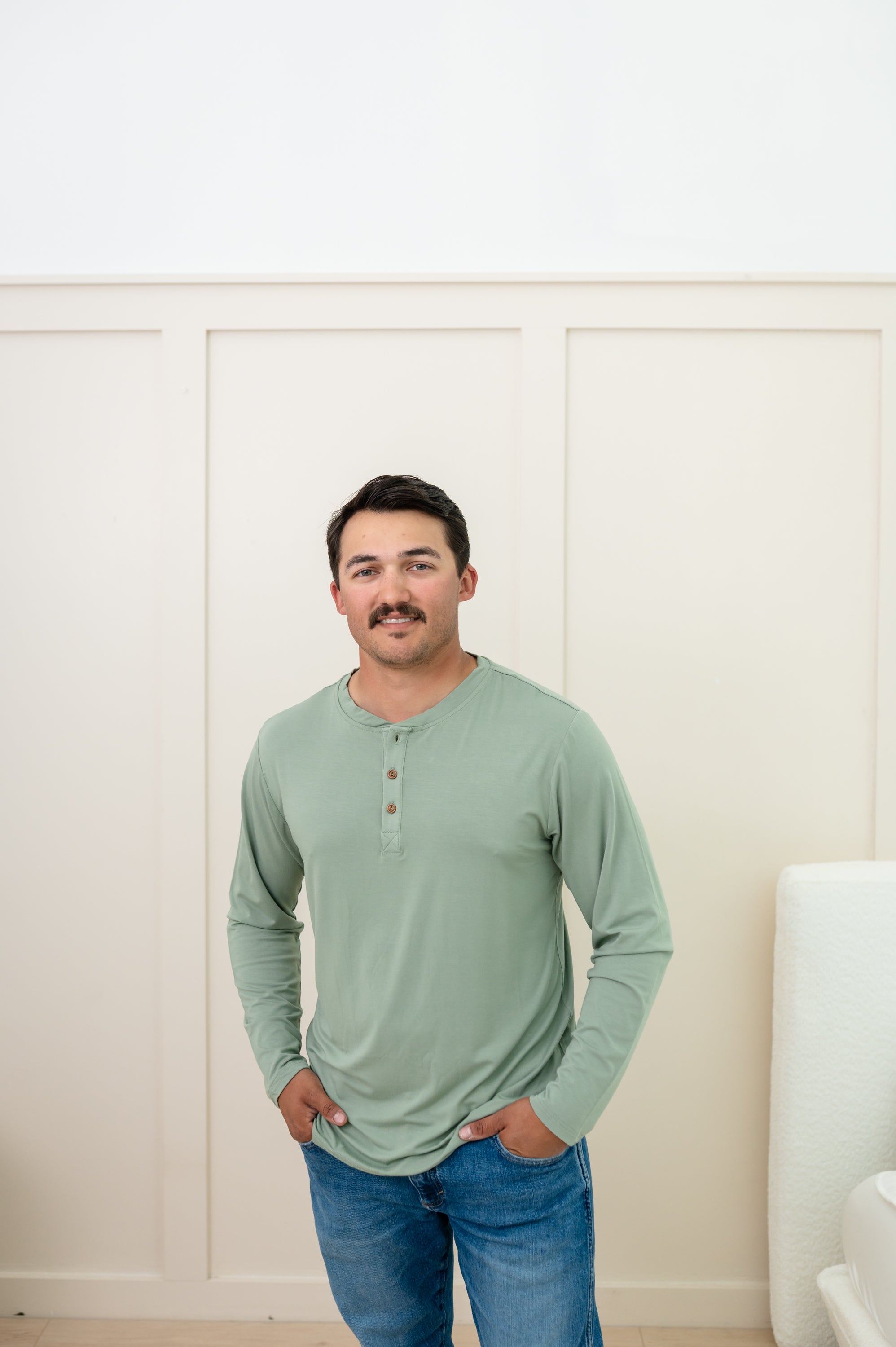 Man modeling Men's Long Sleeve Henley Top in Thyme with jeans