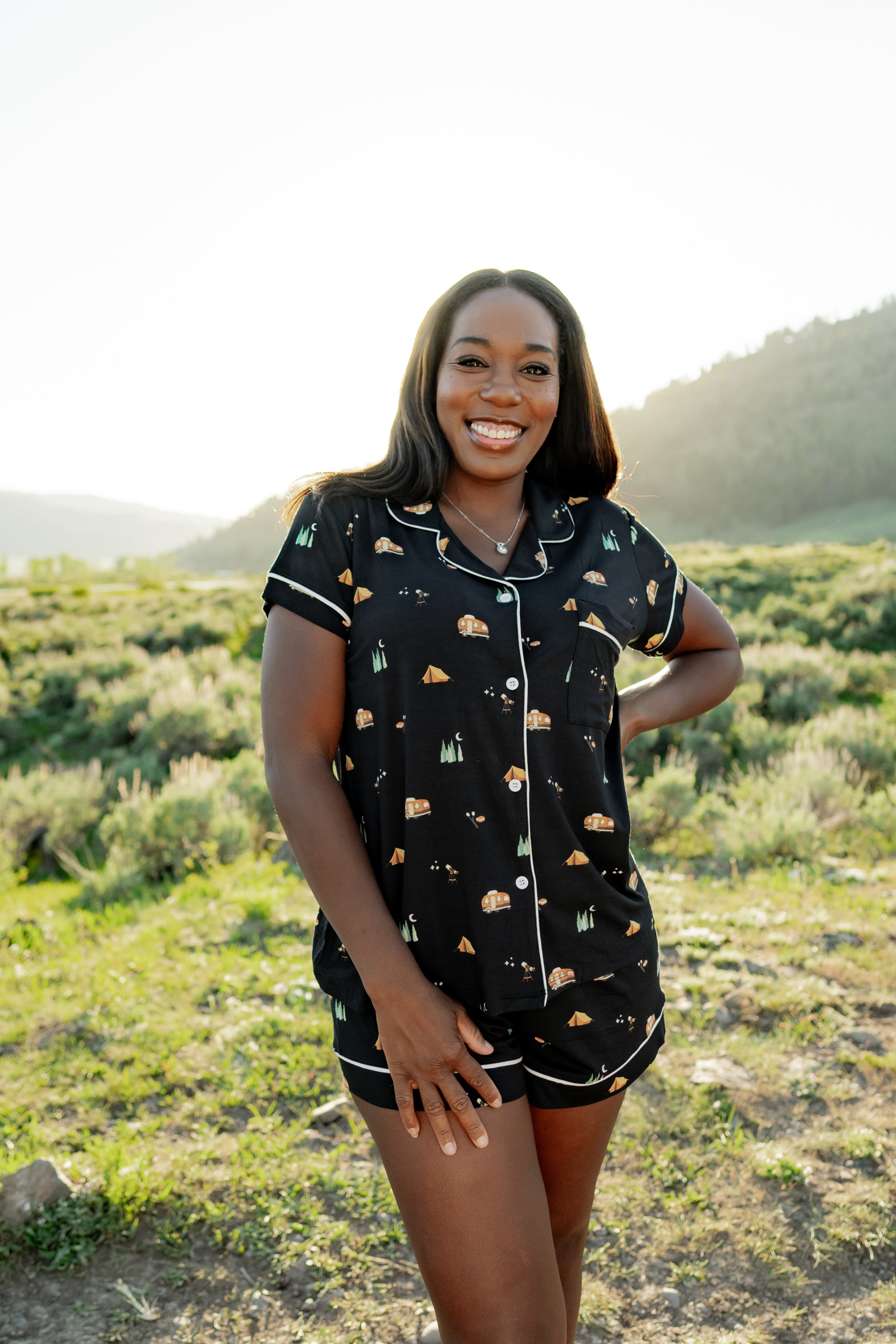 Woman modeling Women's Short Sleeve Pajama Set in Under the Stars with hand on hip in Yellowstone National Park