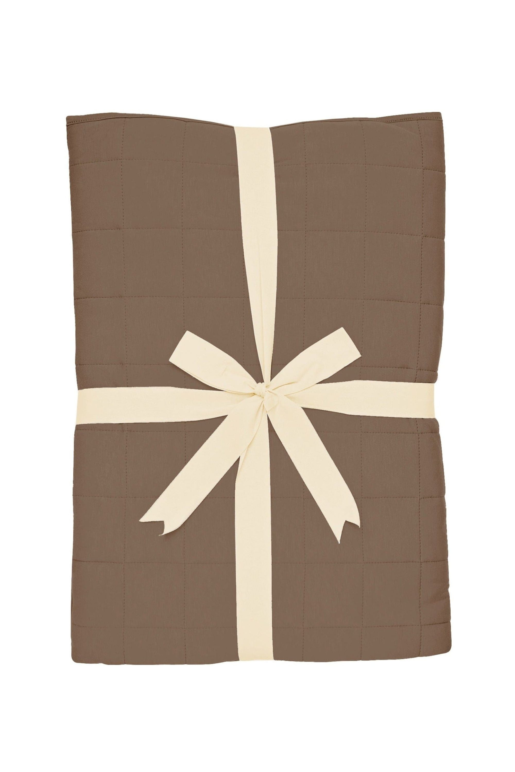 Medium brown quilted throw blanket folded and tied with a ribbon