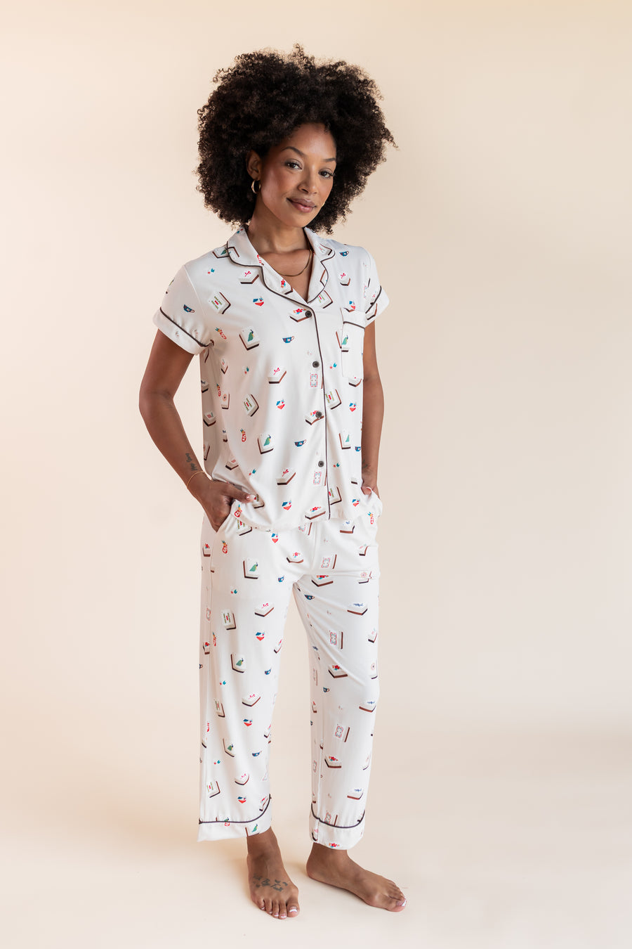 Model wearing Women's Short Sleeve Cropped Pajama Set in Vanilla Mahjong print with pockets on a beige background
