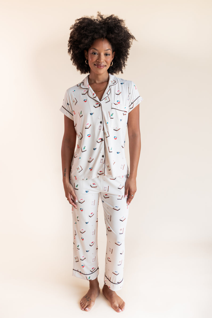 Model smiling in Women's Short Sleeve Cropped Pajama Set in Vanilla Mahjong print on a beige background