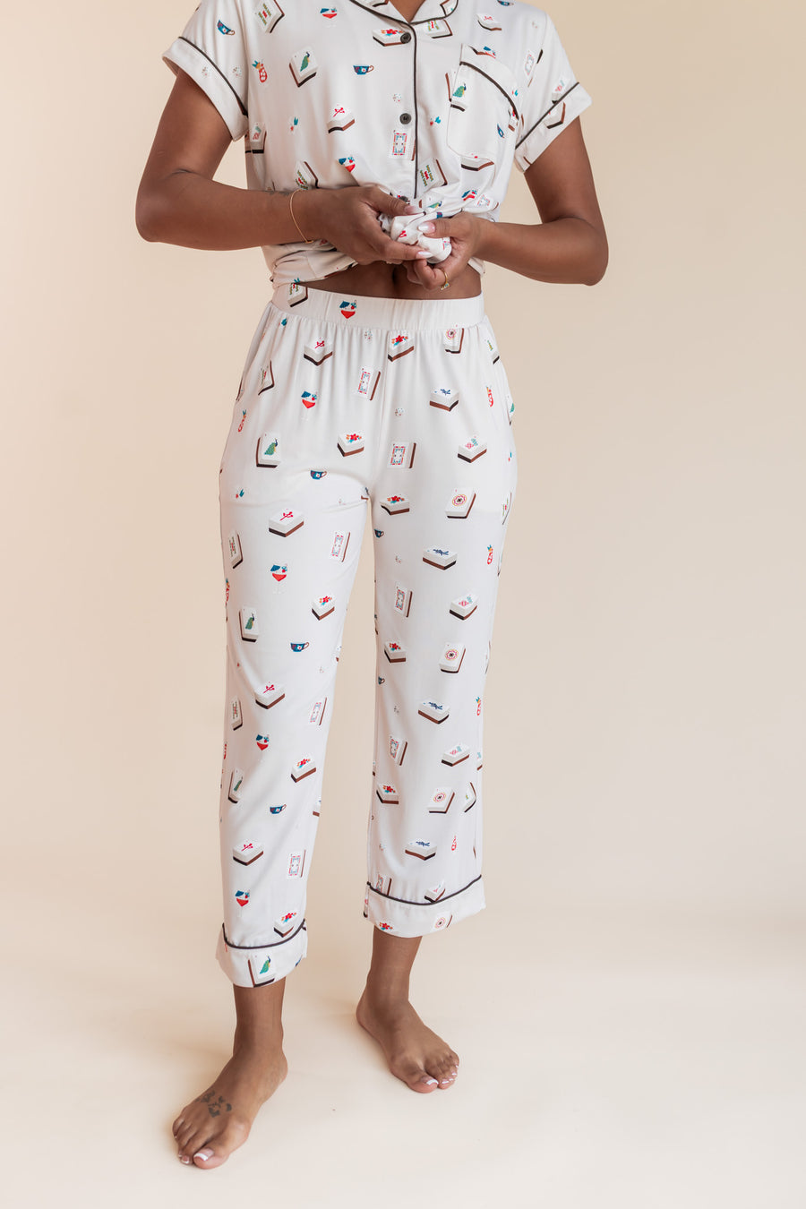 Close up of Model wearing Women's Short Sleeve Cropped Pajama Set in Vanilla Mahjong print on a beige background