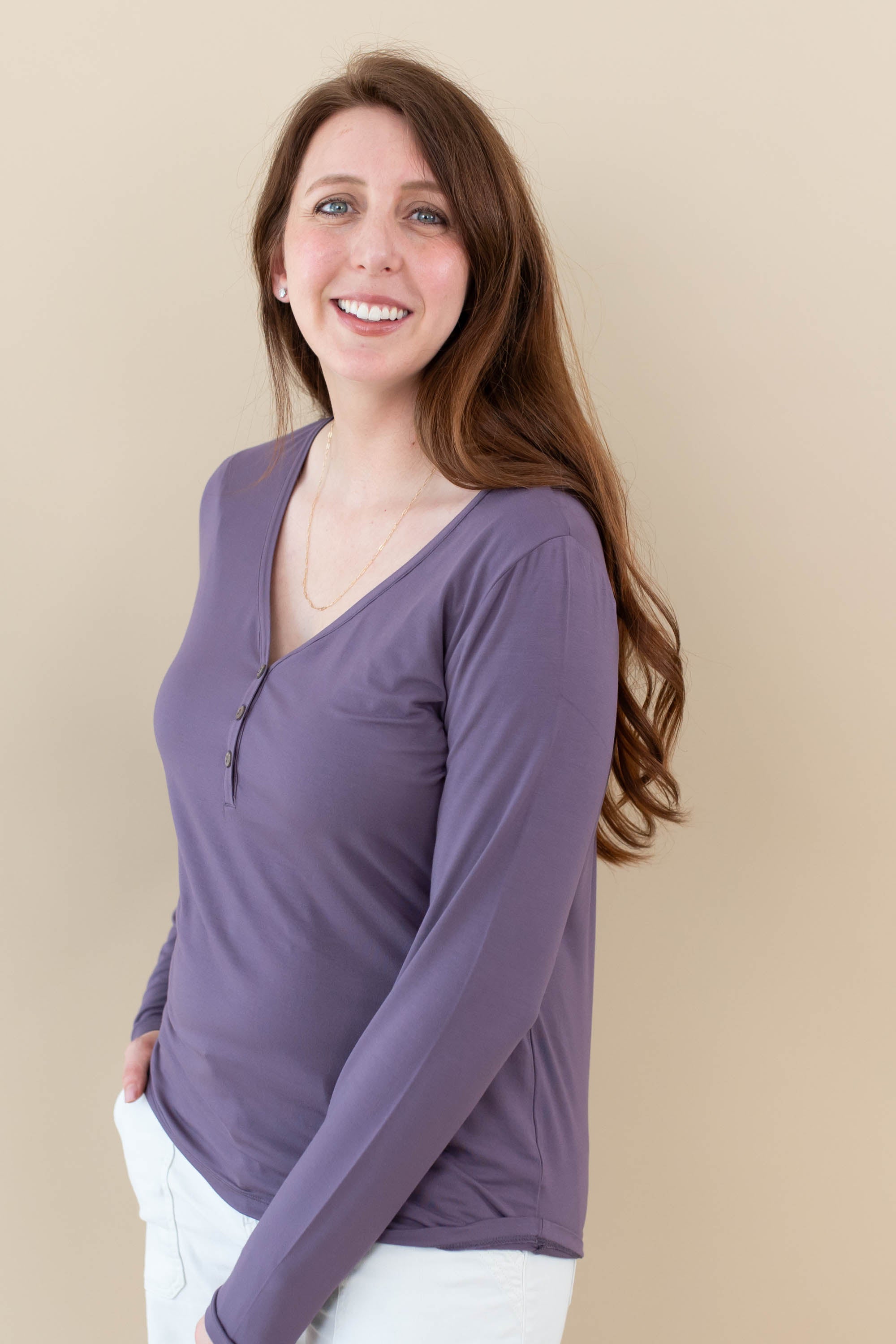 Female model wearing the Women's Long Sleeve Henley Tee in Currant