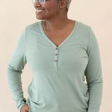 Female model wearing the Women's Long Sleeve Henley Tee in Thyme