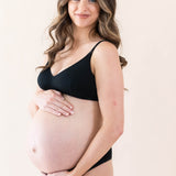 Expectant mother cradling her baby bump wearing the Women's Nursing Bra in Midnight