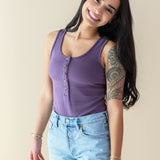 Female model wearing the Women’s Ribbed Henley Bodysuit in Currant paired with Jean Shorts