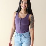 Smiling model wearing the Women’s Ribbed Henley Bodysuit in Currant
