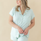 Woman modeling Women's Short Sleeve Pajama Set in Dew holding bottom of pajama top