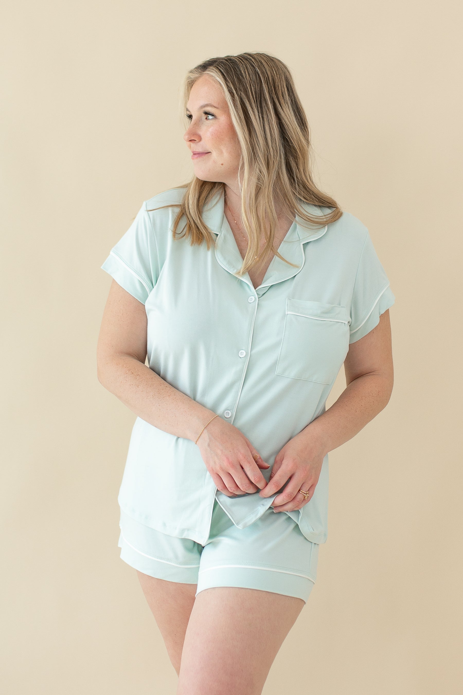 Woman modeling Women's Short Sleeve Pajama Set in Dew holding bottom of pajama top