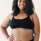 Model wearing Kyte Baby's Women's Scoop Neck Bralette in Midnight paired with Midnight Jogger bottoms