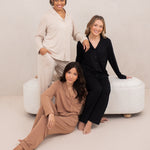 Three female models wearing the Long-Sleeved Women's Pajama Set in Latte with Latte Trim, Midnight with Midnight Trim and Bisque with Bisque Trim