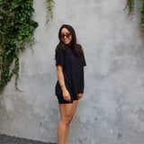 Woman modeling Women’s Biker Short Set in Midnight against a concrete wall with trailing vines