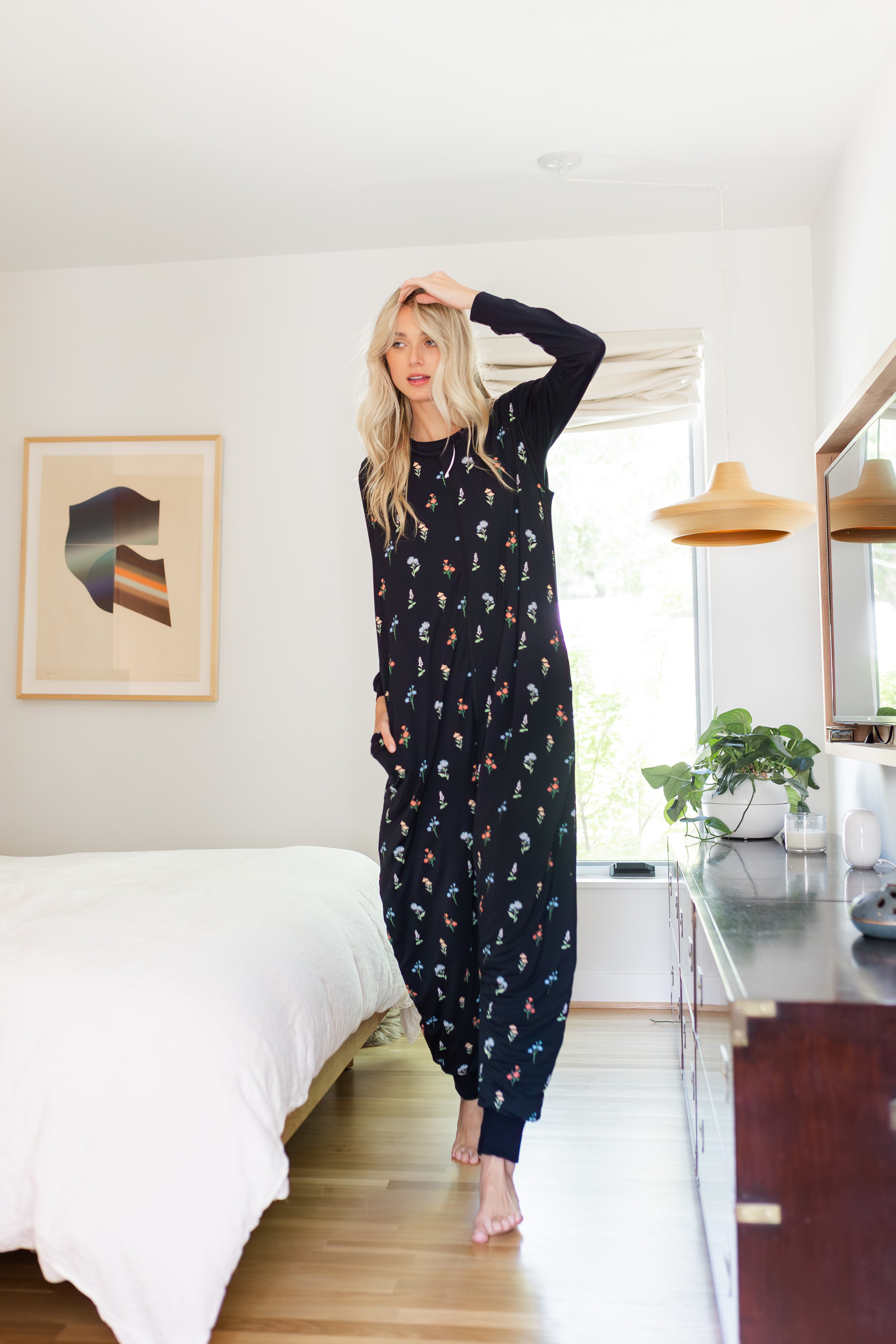 Model wearing the Long Sleeve Adult Sleep Bag Walker in Midnight Wildflower standing in bedroom