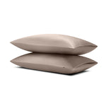 Two pillows stacked on top of the other with the Bamboo Sateen Pillowcases in Truffle on them