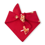 A red bandana tie-on bow featuring a printed pattern of gingerbread