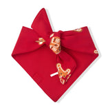 A red bandana tie-on bow featuring a printed pattern of gingerbread