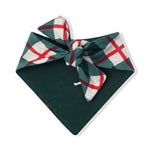 A dark green pet bandana featuring a plaid patterned tie in green, white, and red, displayed on a clean white background.