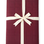 Adult Quilted Blanket in Burgundy 2.5 wrapped in a ribbon bow on a white background