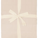 Product photo of the Bamboo Quilt Blanket in Bisque 2.5 wrapped in an ivory bow