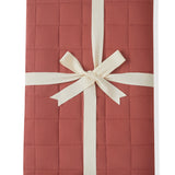 Adult Quilted Blanket in Ember 2.5 packed in a ribbon bow on a white background