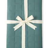 Adult Quilted Blanket in Pine 2.5 wrapped in a ribbon bow on a white background