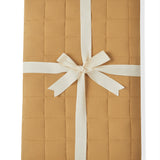 Adult Quilted Blanket in Ochre 2.5 wrapped in a ribbon bow on a white background